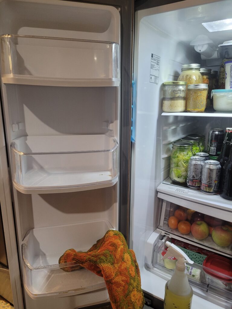 refridgerator door empty with towel and cleaning spray next to it