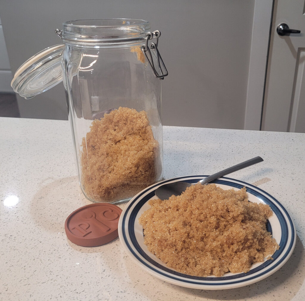 Brown sugar sitting on plate with jar behind it