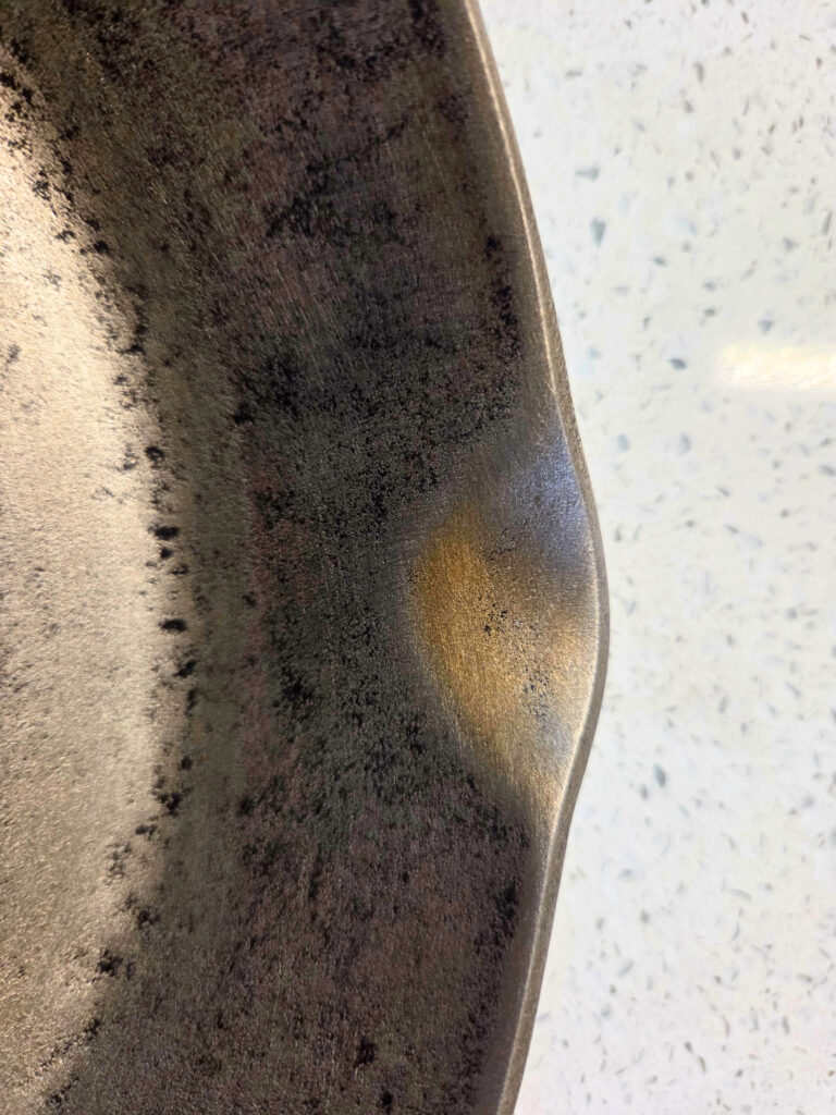 Beginning of Rust on a Cast Iron Pan - Resurface a Cast Iron Pan close up of a cast iron pan with rust on the edge