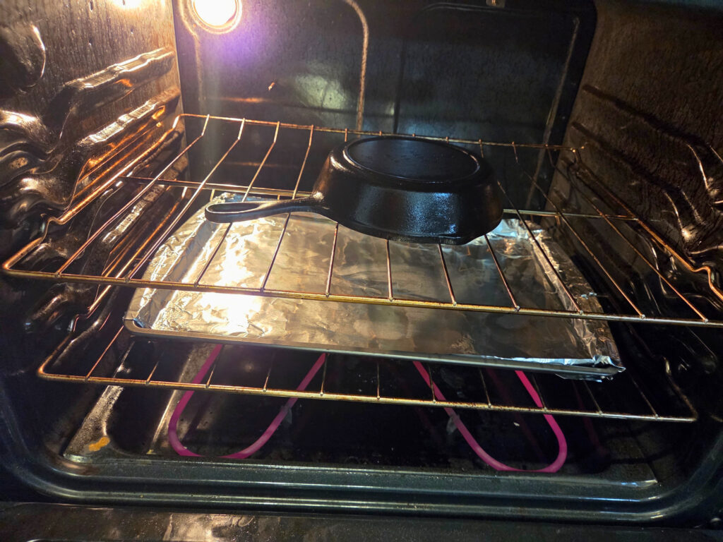 Placement in Oven - Seasoning a Cast Iron Pan Cast Iron pan upside down in the oven with an aluminum foiled pan underneath it