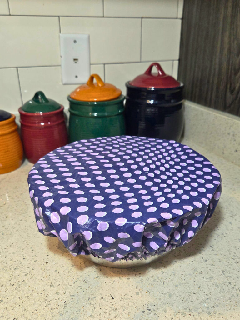 a covered bowl on a counter with jars